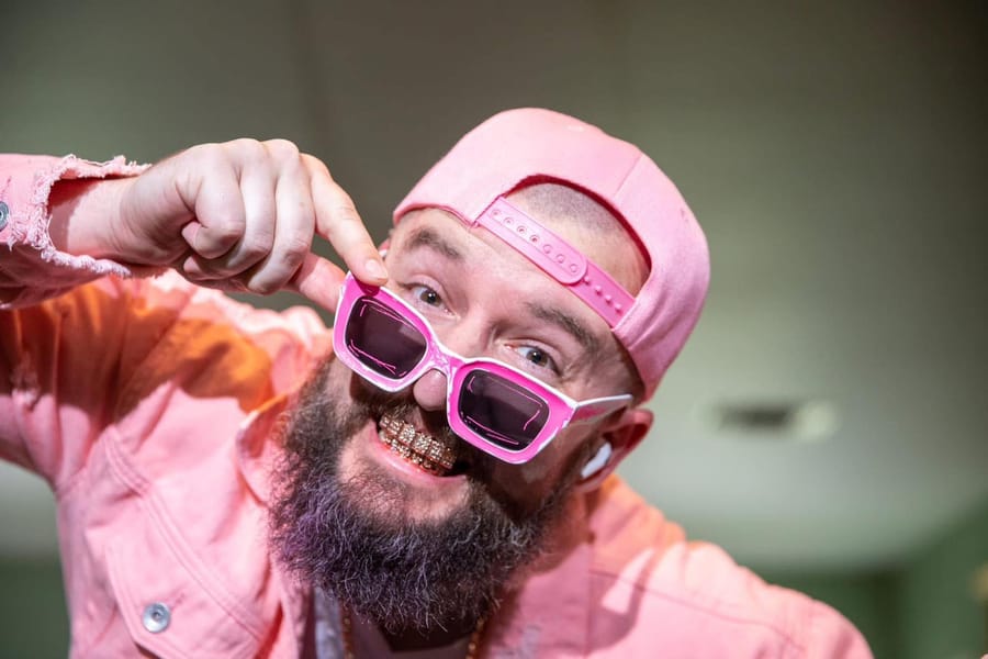 Me in a Halloween costume: pink backwards cap, pink denim jacket, pink sunglasses pulled down, and a gold grill.